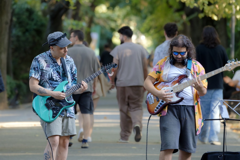 Men playing electric guitars in the park